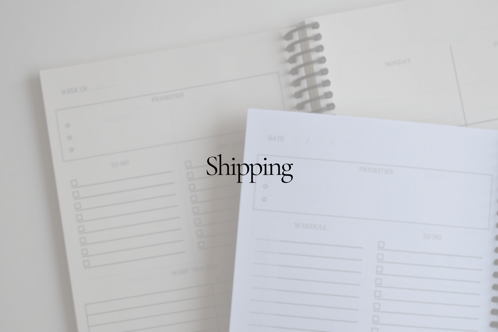 Two open spiral planners stacked on top of each with overlay text "Shipping"
