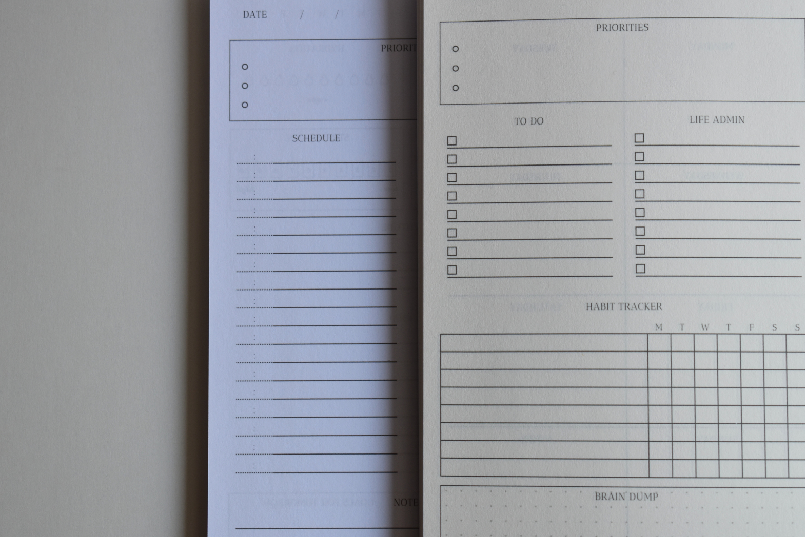 Two planners side by side with two different page colors, white and cream